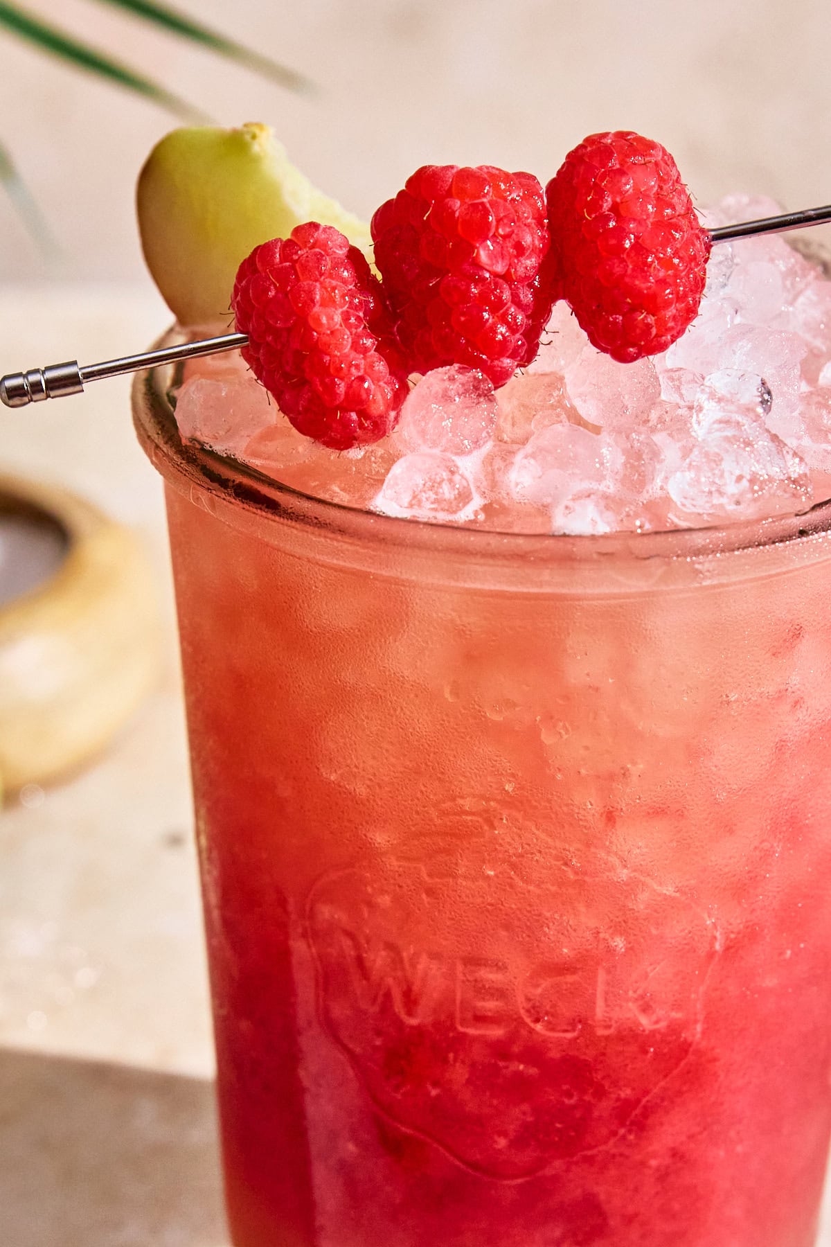 raspberry white peach gatorade in a mason jar topped with three raspberries