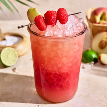 white peach raspberry gatorade in a mason jar with ice and topped with raspberries