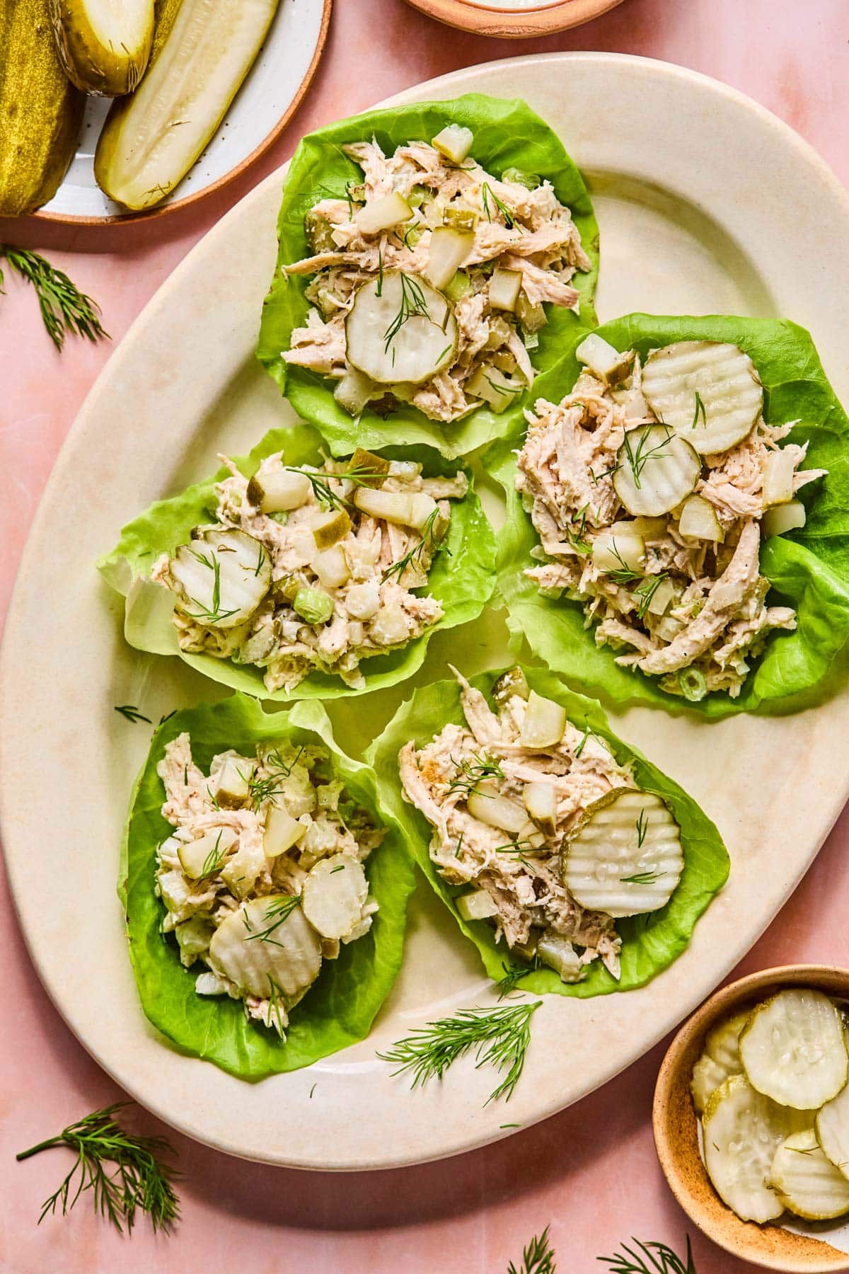 chicken salad scooped atop butter lettuce leaves and garnished with pickle slices and fresh dill 