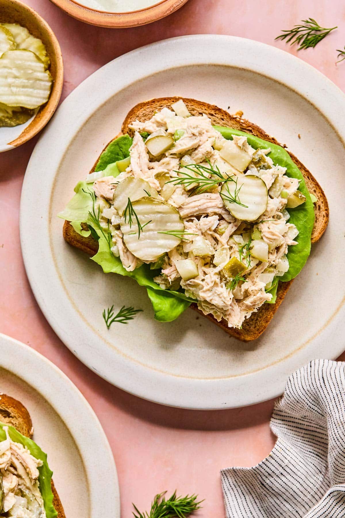 dill pickle chicken salad spread on top of a piece of bread with butter lettuce