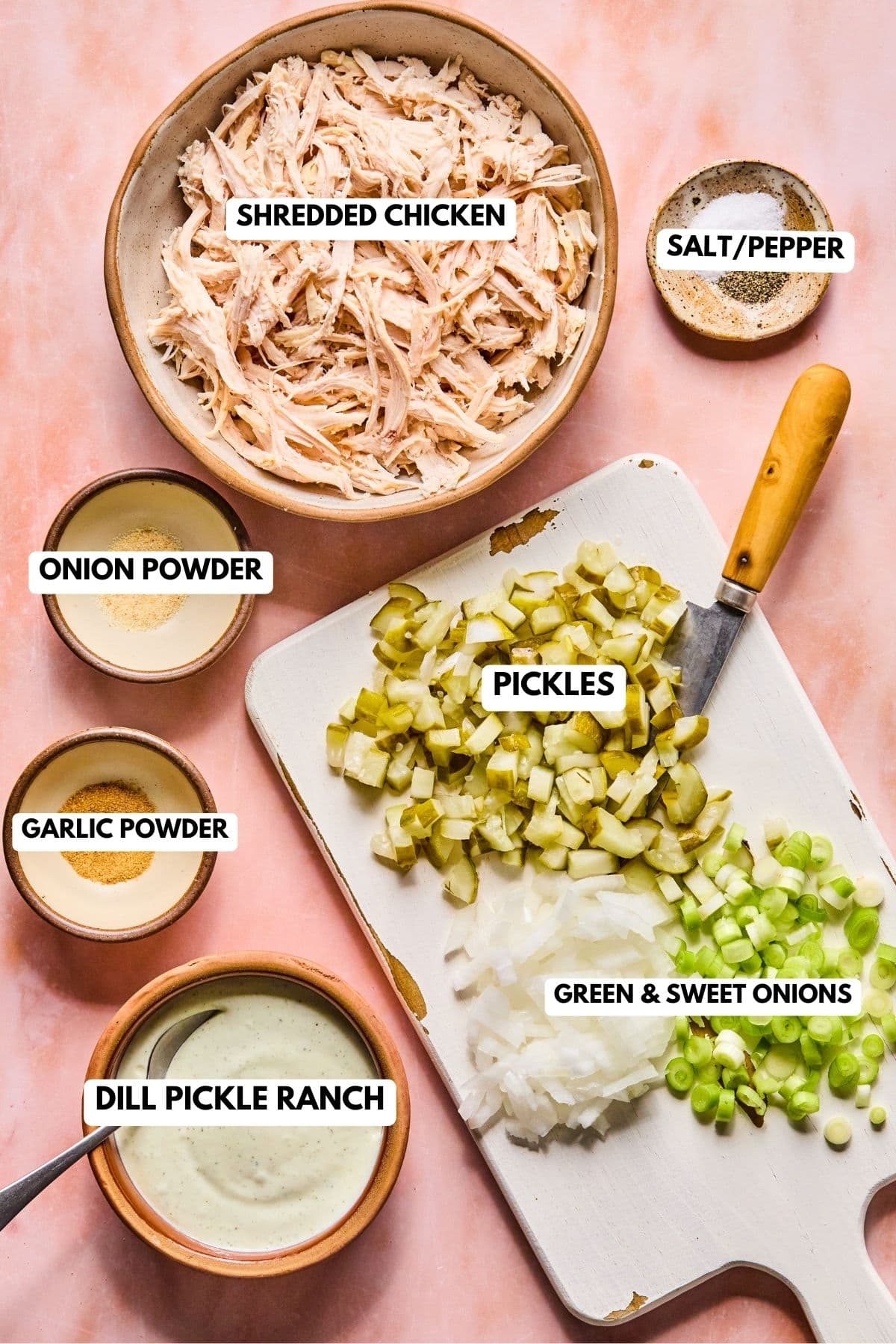 recipe ingredients for this chicken salad in bowls including shredded chicken, chopped pickles, and spices