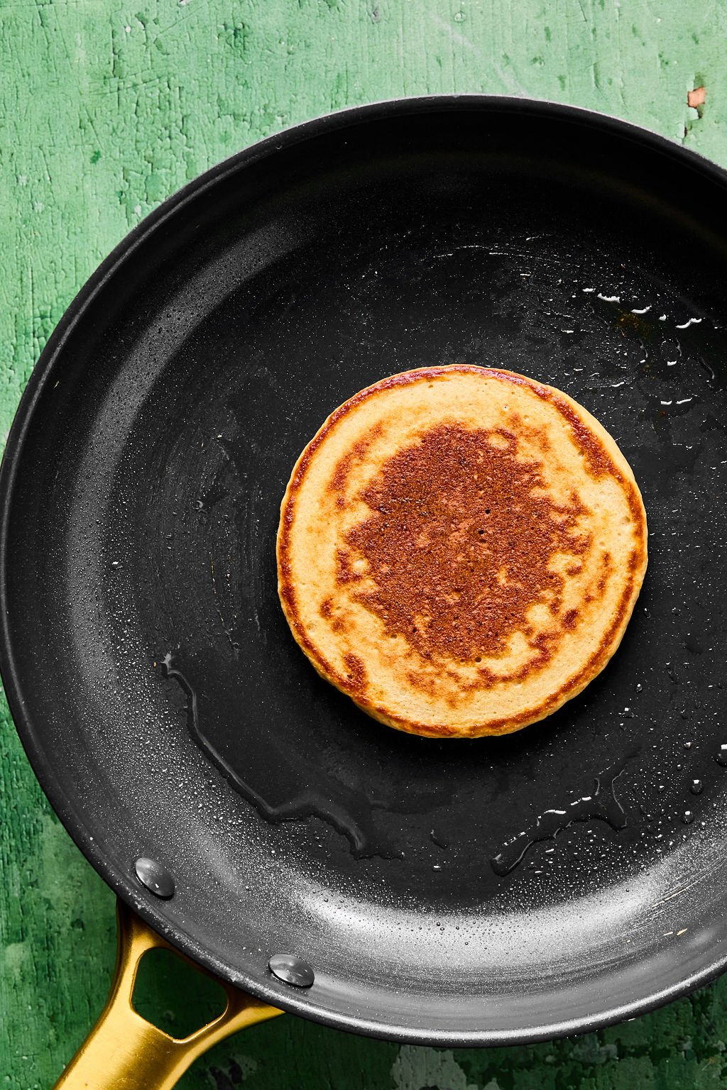 Cooked gingerbread pancake on a black skillet.