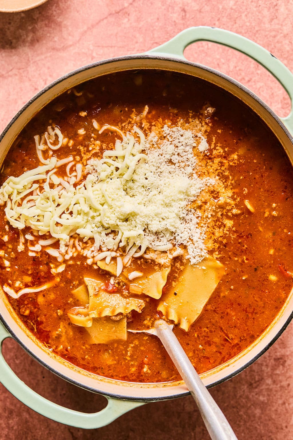 Mozzarella and parmesan being stirred into the soup.