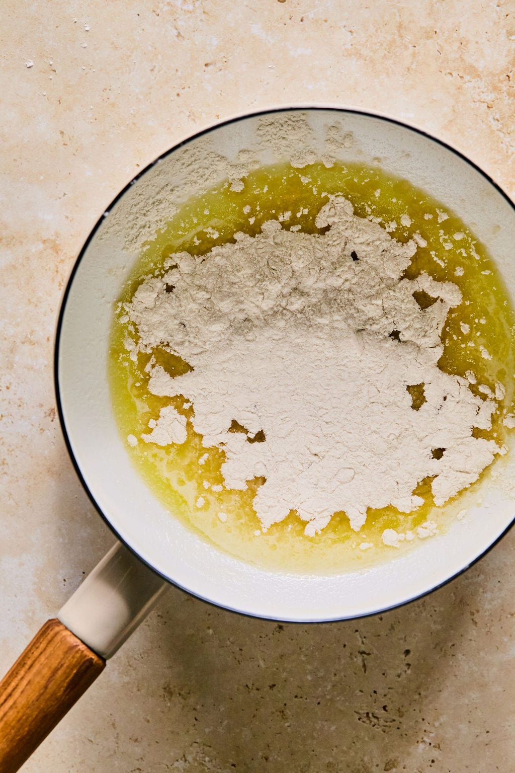 Melted butter in a small saucepan with flour, ready to whisk in.