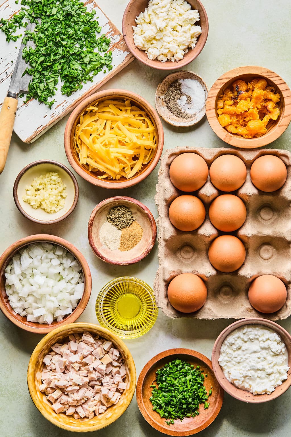 Ingredients for Thanksgiving frittata breakfast muffins laid out on a light colored countertop. 