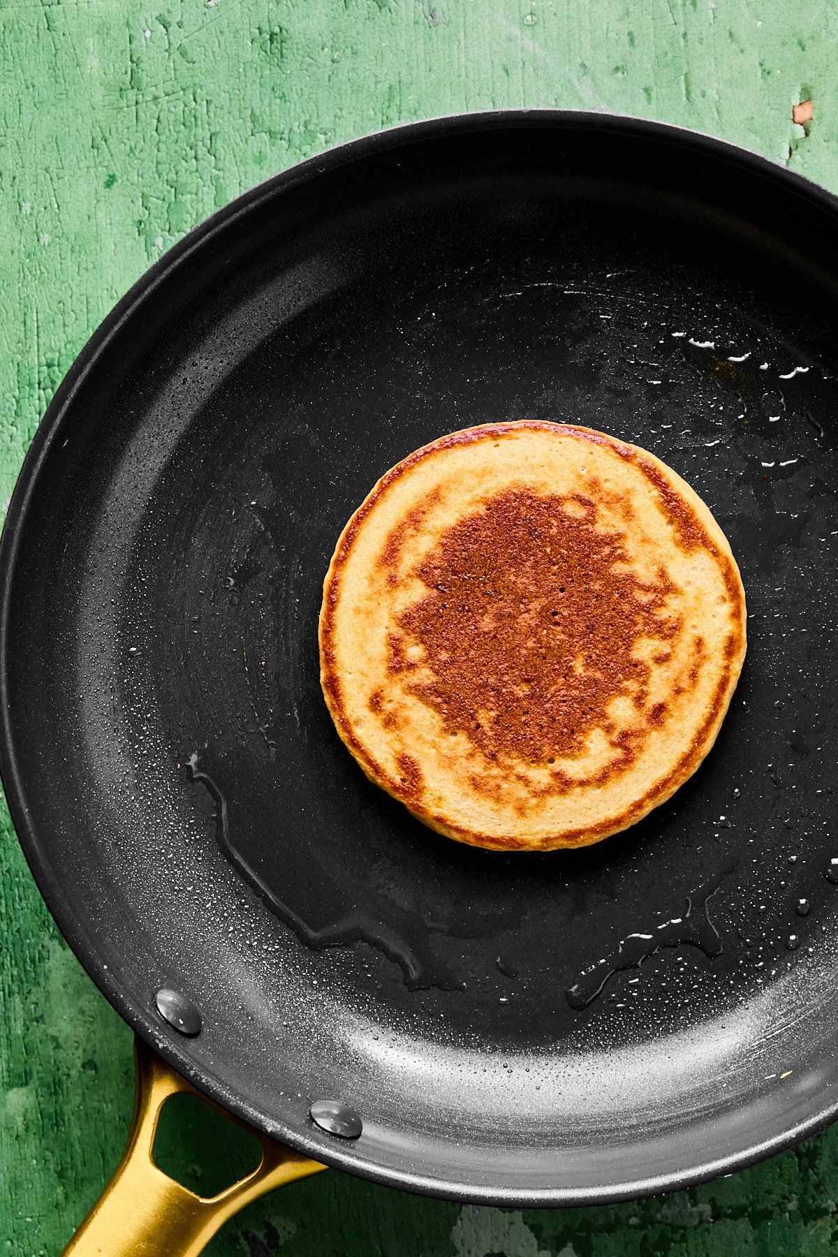 Cooked gingerbread pancake on a black skillet.
