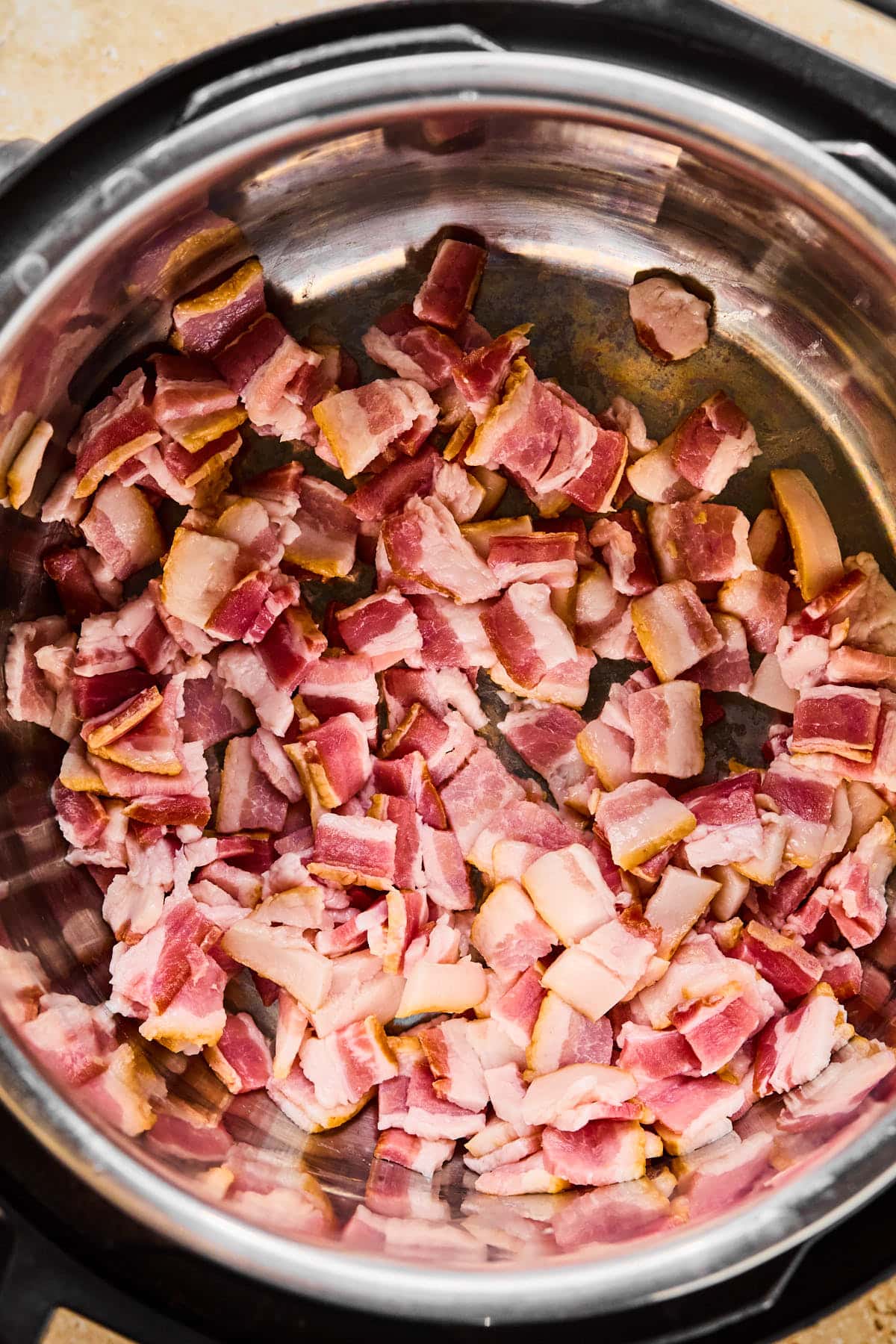 Chopped bacon cooking in the Instant Pot on Sauté mode.