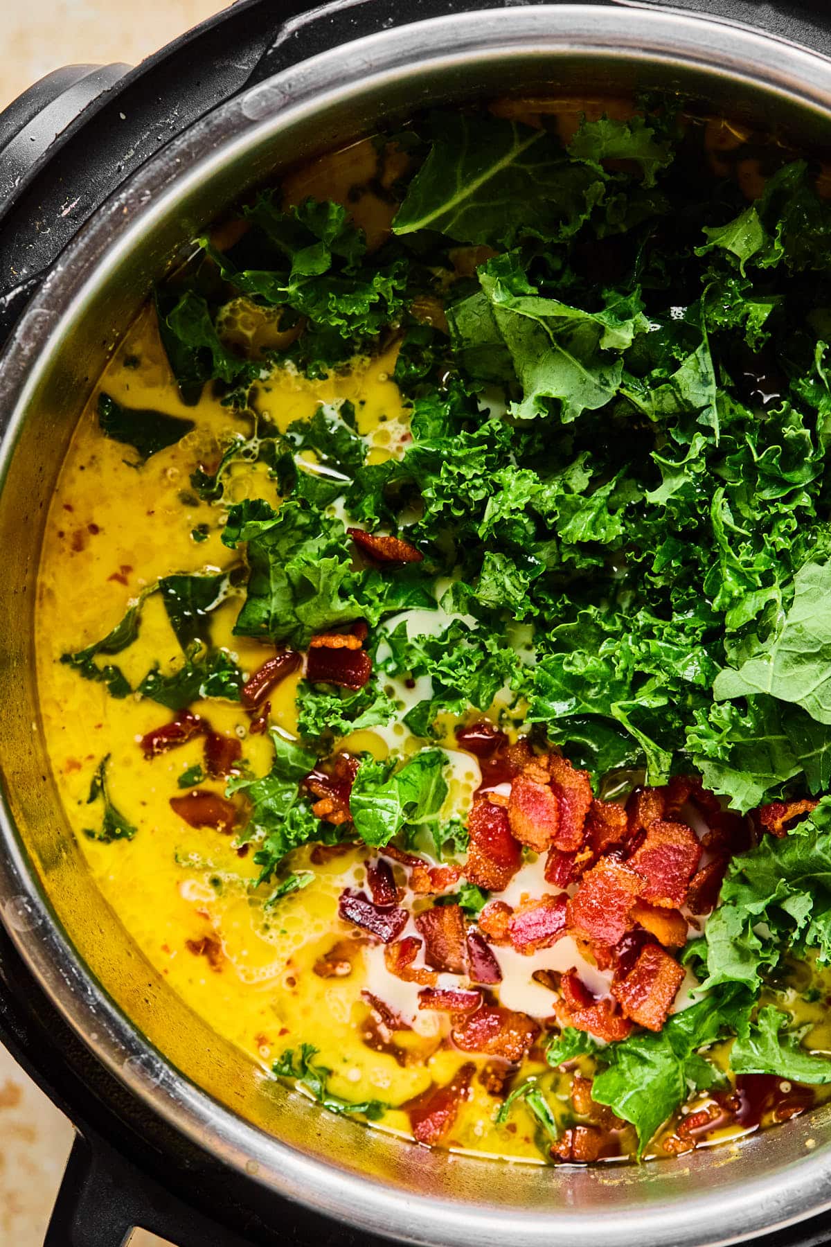 Coconut milk,chopped kale, and crispy bacon stirred into Instant Pot zuppa toscana.