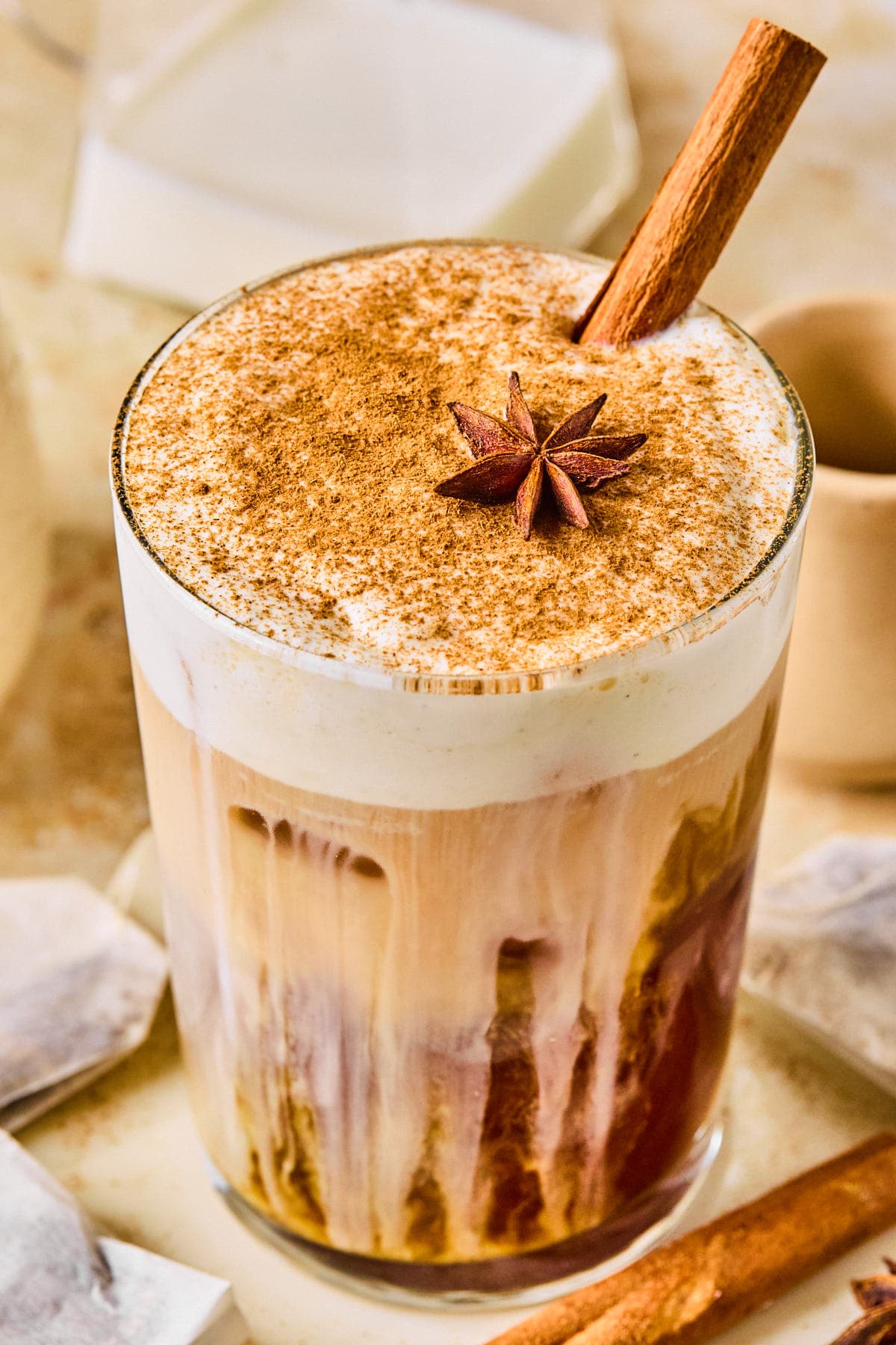 Iced dirty chai latte layered with chai concentrate, espresso, and milk over ice, topped with vanilla bean cold foam and a dusting of cinnamon.
