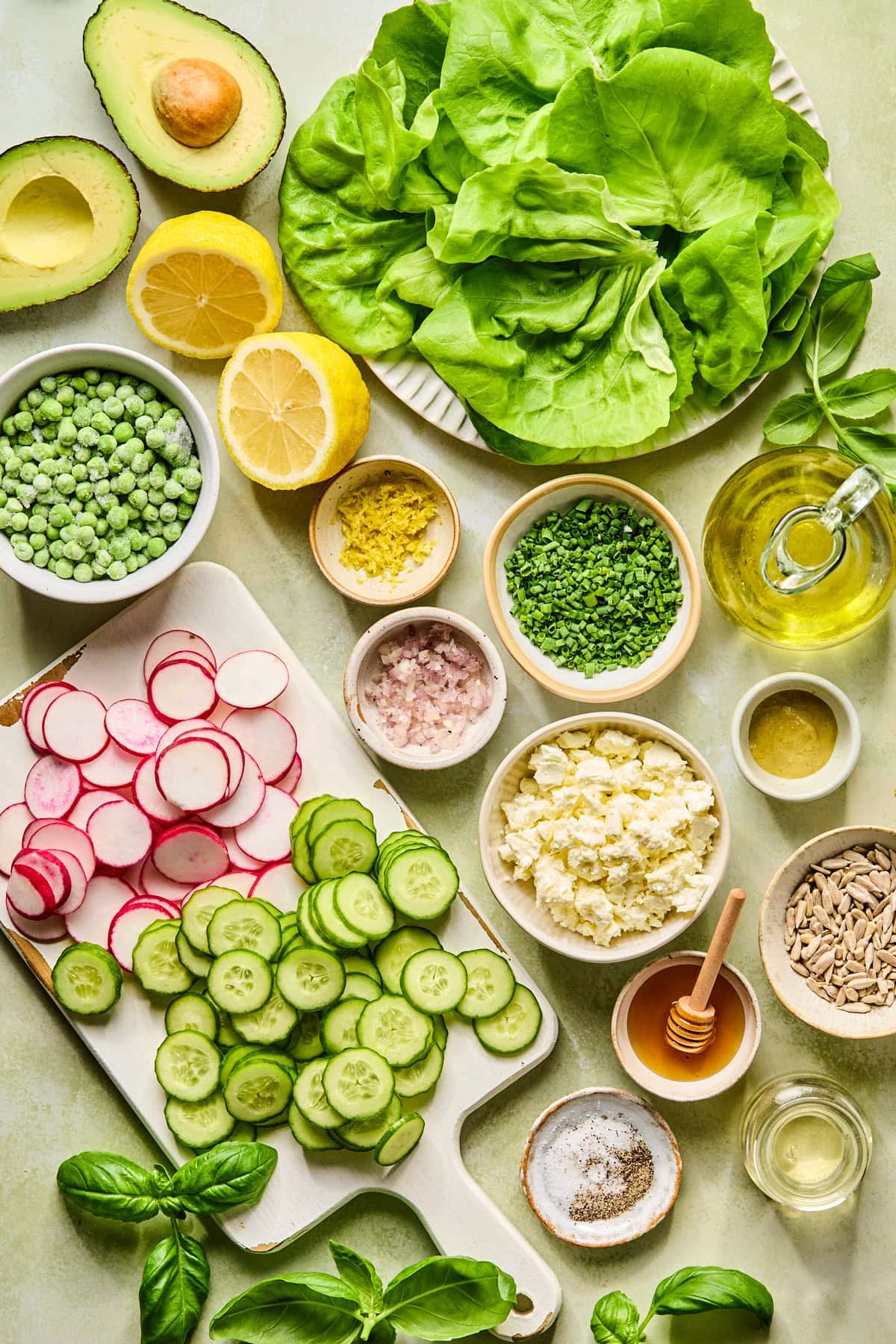 Ingredients for spring salad laid out on a light colored countertop.