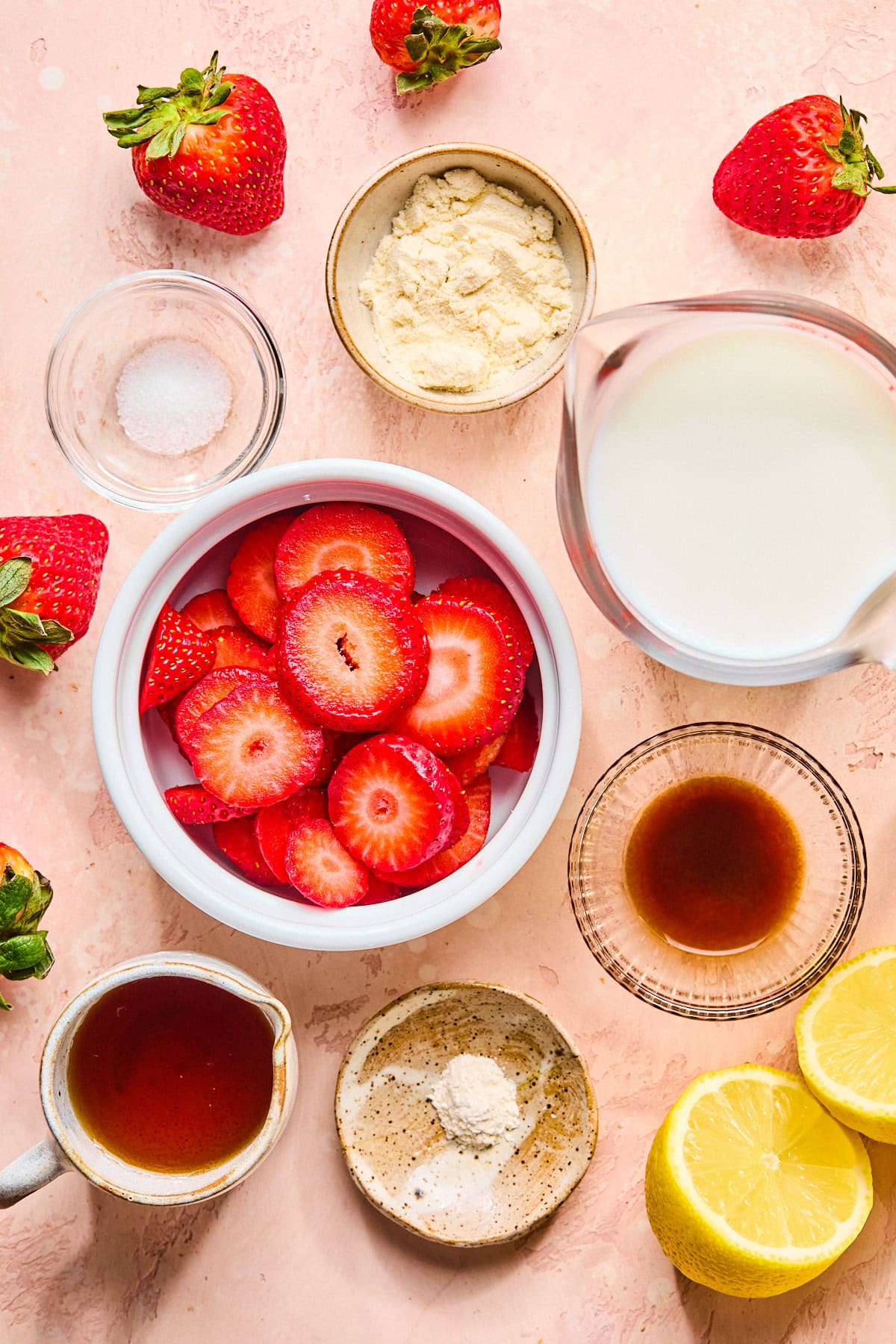 Ninja Creami strawberry ice cream recipe ingredients laid out on a light pink countertop.