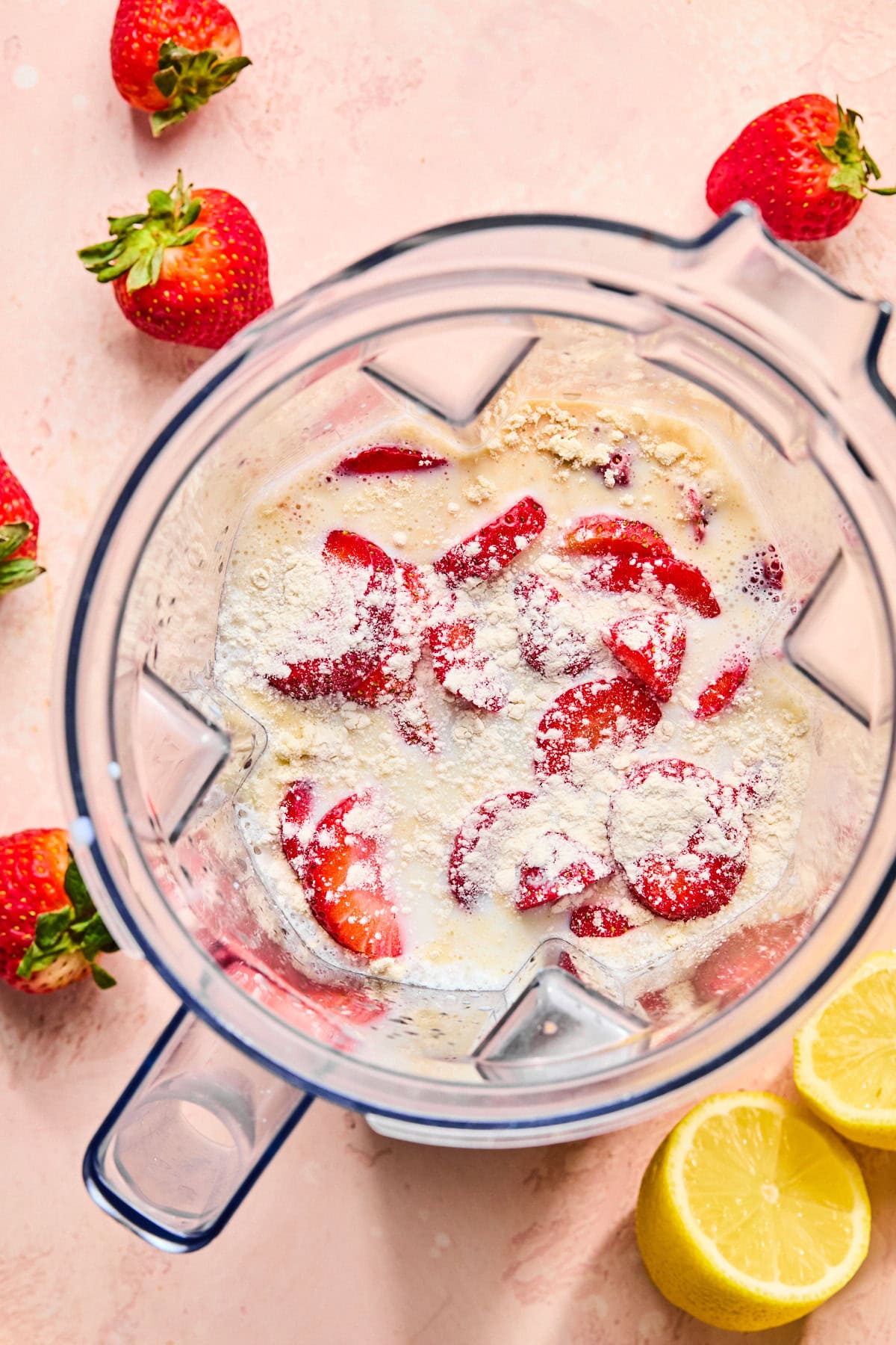 Ingredients for Ninja Creami strawberry ice cream added to Ninja Creami, with xanthan gum sprinkled evenly on top before blending.