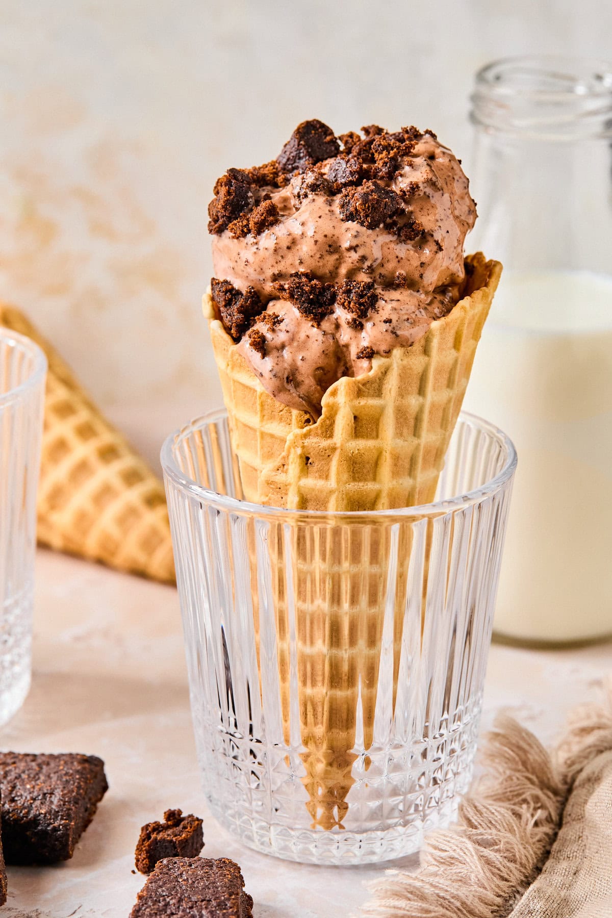 Waffle cone filled with Ninja Creami chocolate ice cream, topped with dark chocolate chunks.