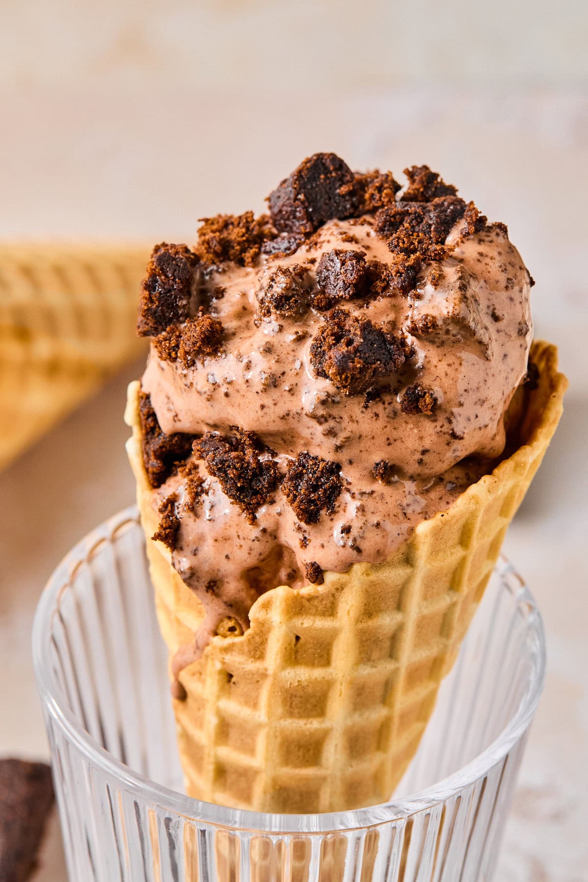 Waffle cone filled with Ninja Creami chocolate ice cream, topped with dark chocolate chunks.