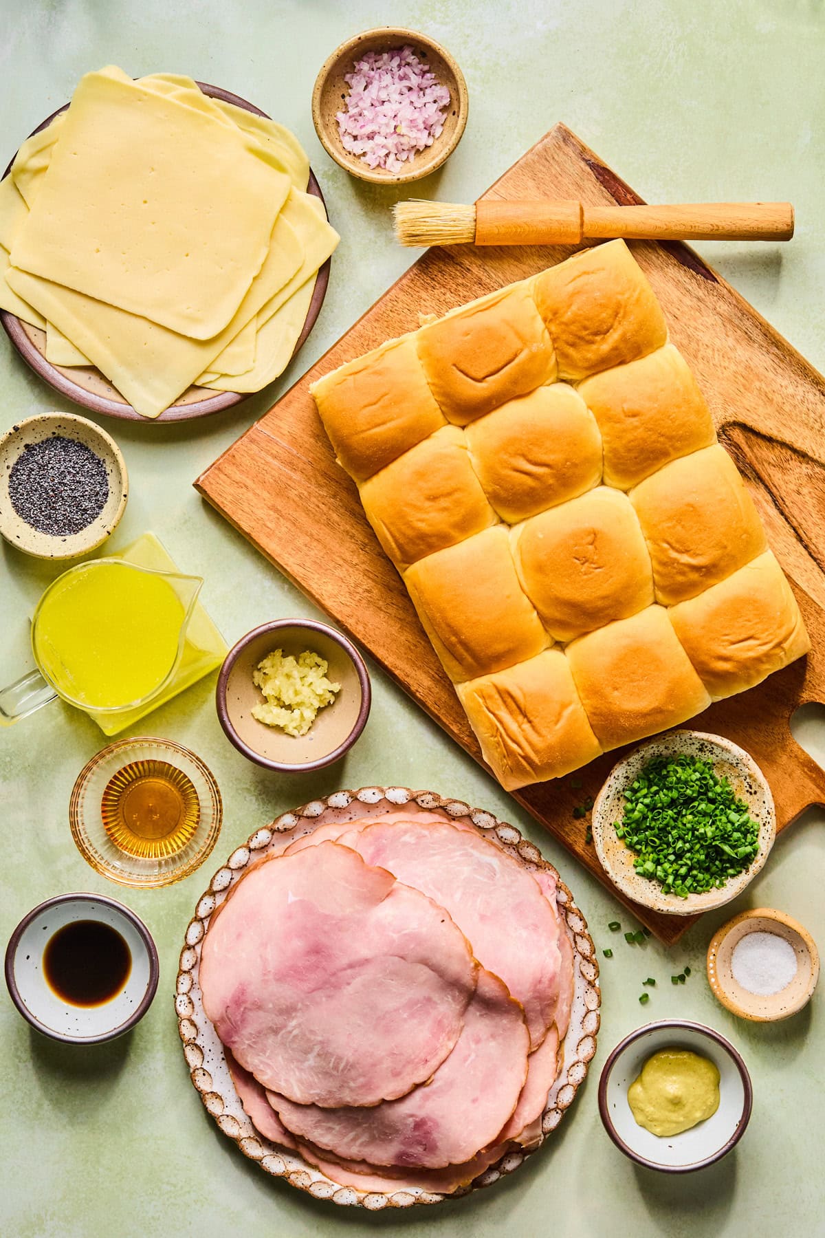 Recipe ingredients for hot ham and cheese sliders laid out on a countertop.