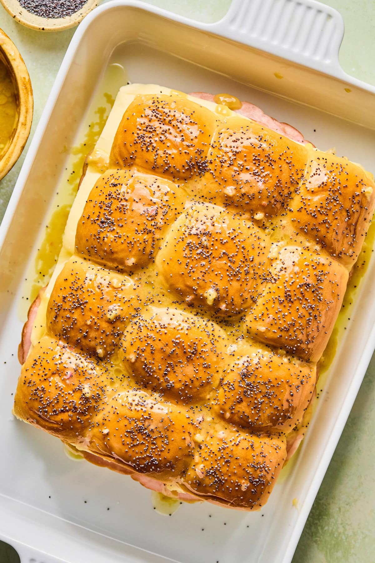 Freshly baked hot ham and cheese sliders that are golden on top.