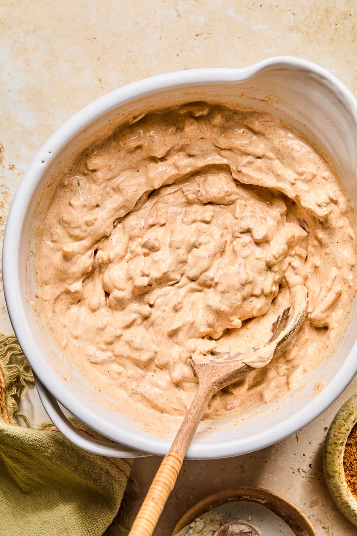 Bowl of boat dip with a wooden spoon in it after refrigerating.