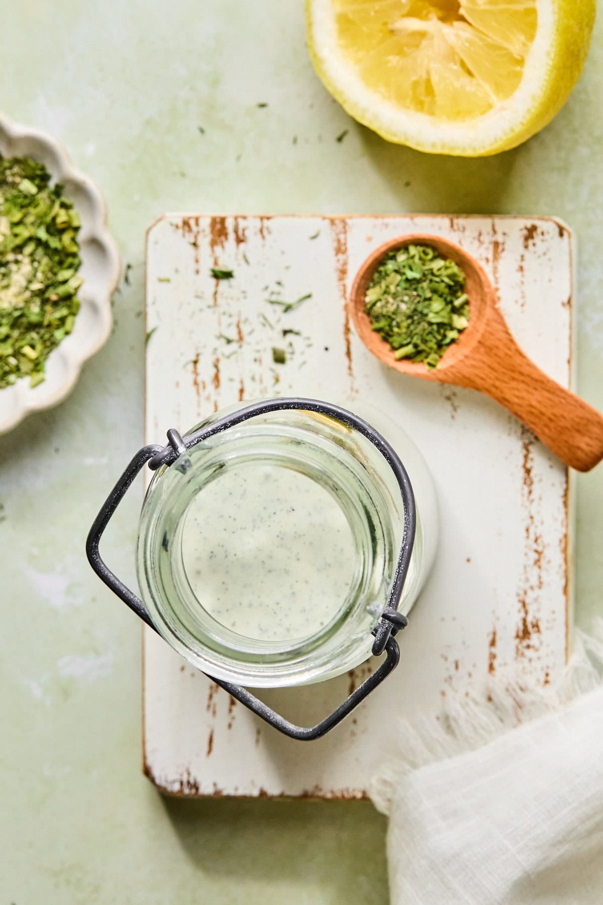 Birds eye view of high protein ranch in a jar on a white rustic wooden cutting board after being refrigerated.
