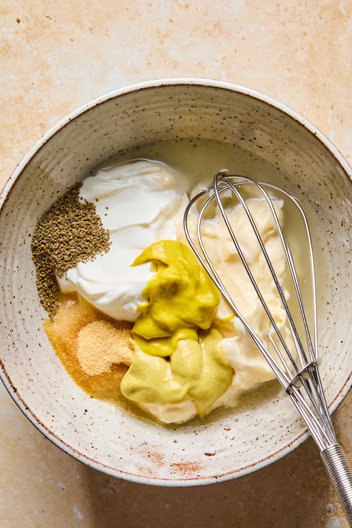 Homemade potato salad dressing in a bowl, ready to be whisked whisked together.