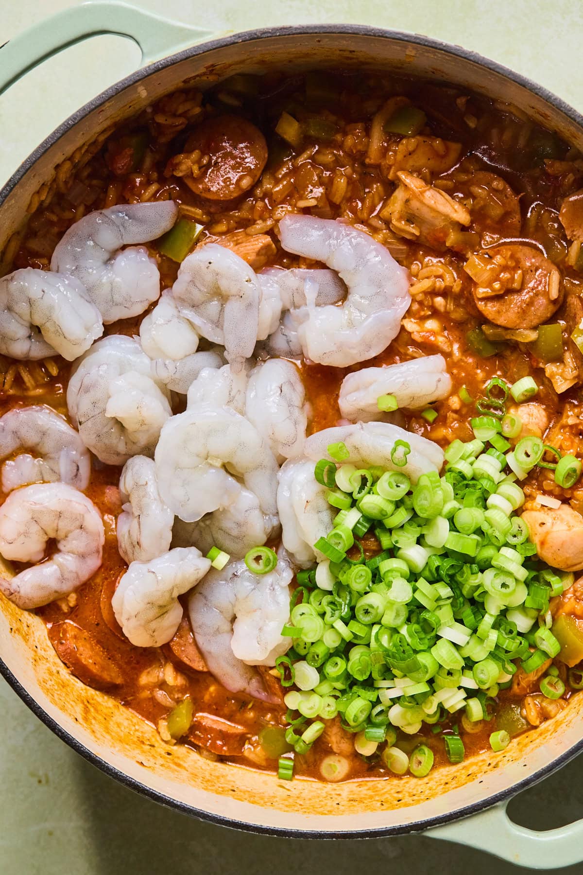 Shrimp and sliced green onions added into the jambalaya.