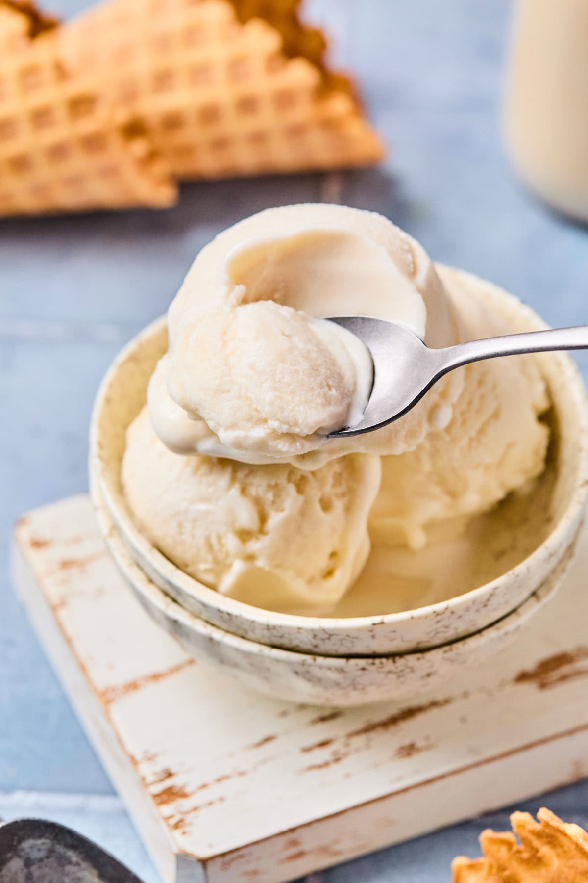Close-up of creamy Ninja Creami vanilla ice cream in a bowl with a spoon scooping up a bite.