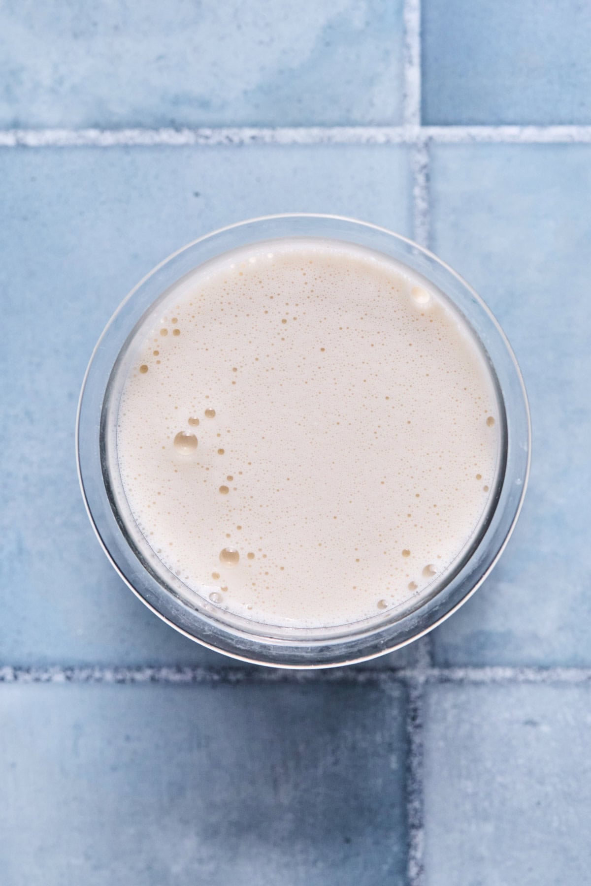 Frozen vanilla ice cream ingredients in a Ninja Creami pint container.