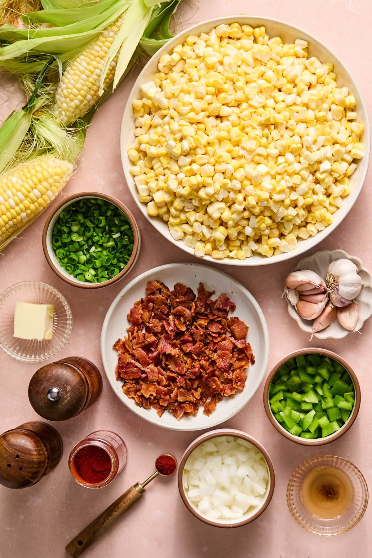 Fried corn recipe ingredients laid out on a light pink countertop.