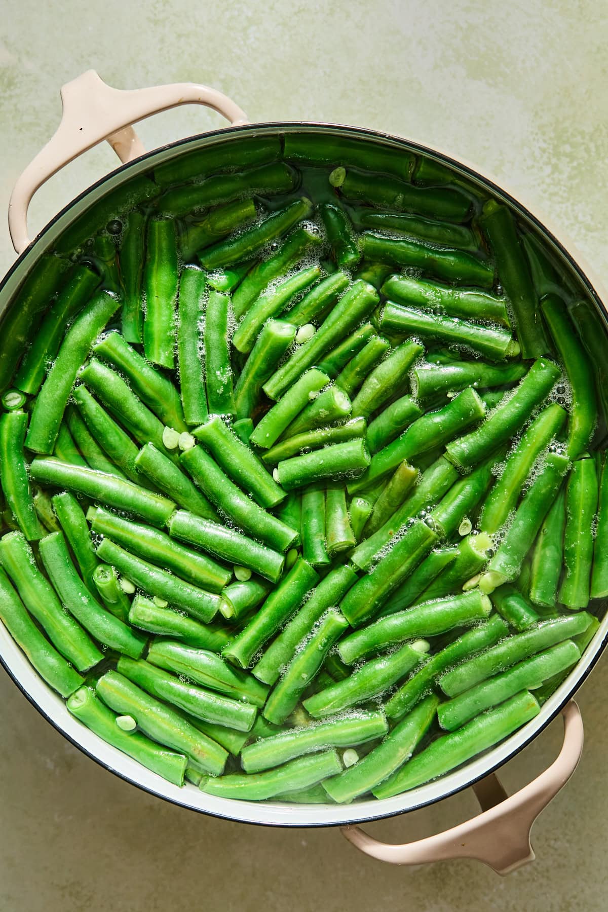 Green beans getting blanched in a pot of water.