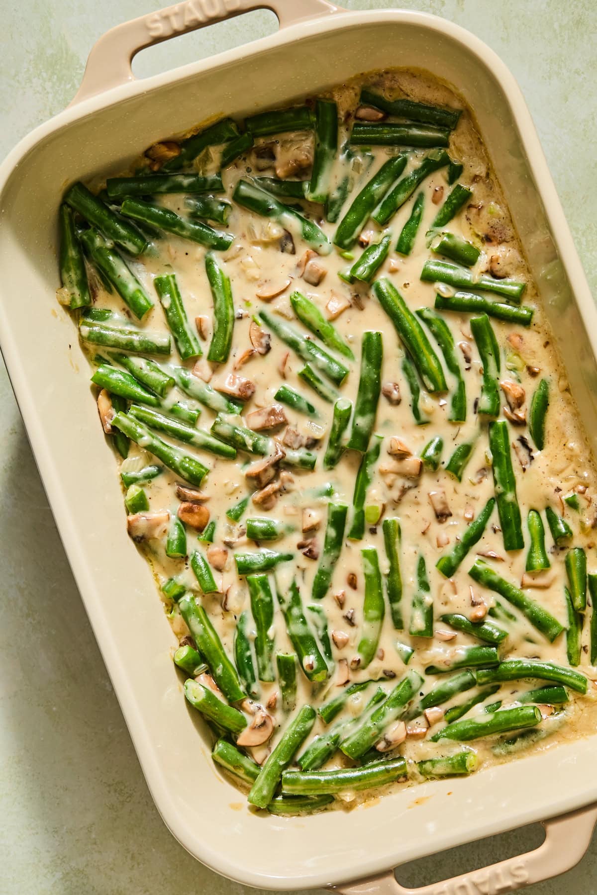 A green bean casserole out of the oven before adding the crispy friend onion topping.