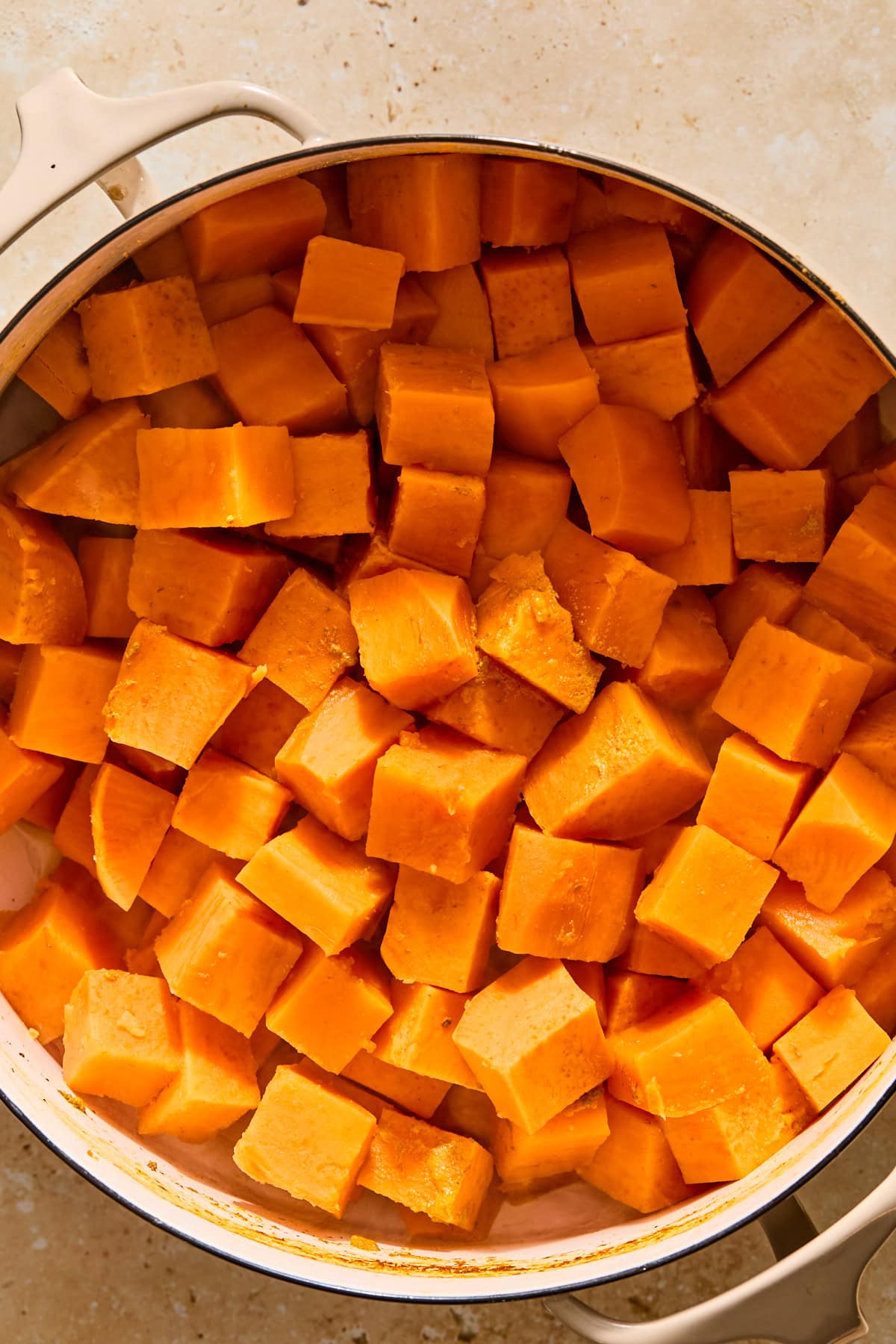 Cooked sweet potato cubes in a large pot after the water is drained but before they are mashed.