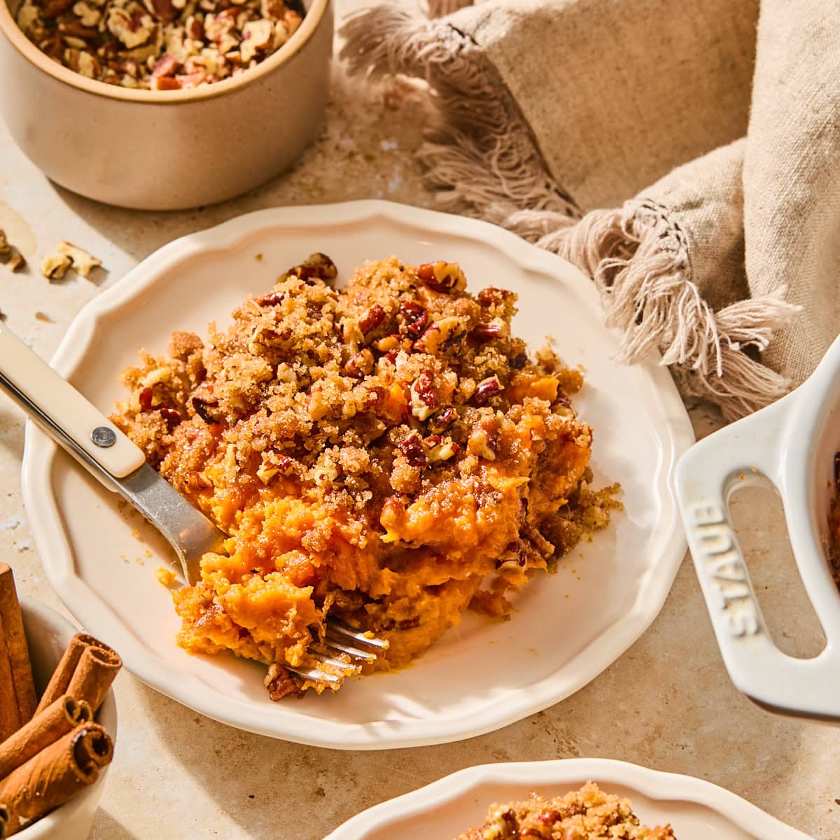A slice of sweet potato casserole on a plate with a fork.